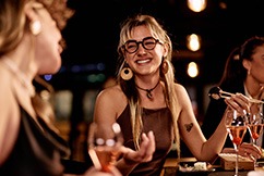 Friends smiling while enjoying meal together