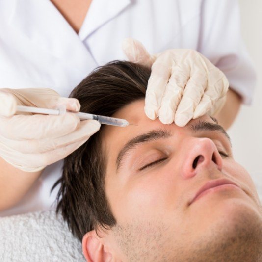 Man receiving Botox injection in forehead