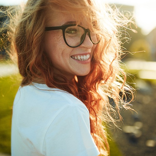 Smiling woman with glasses outdoors 