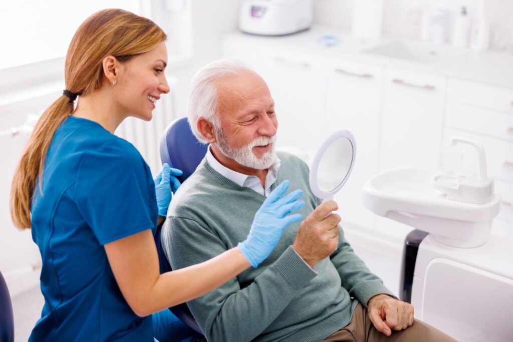 A man sitting in a dentist’s chair and a female dentist.