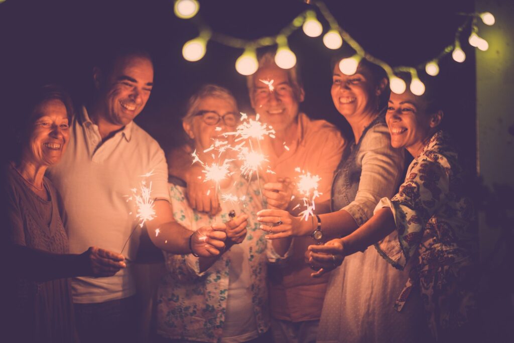 Group of adults holding sparklers together on New Years